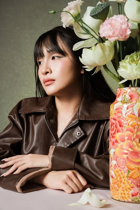 ceramic vase, woman, brown jacket, floral decoration