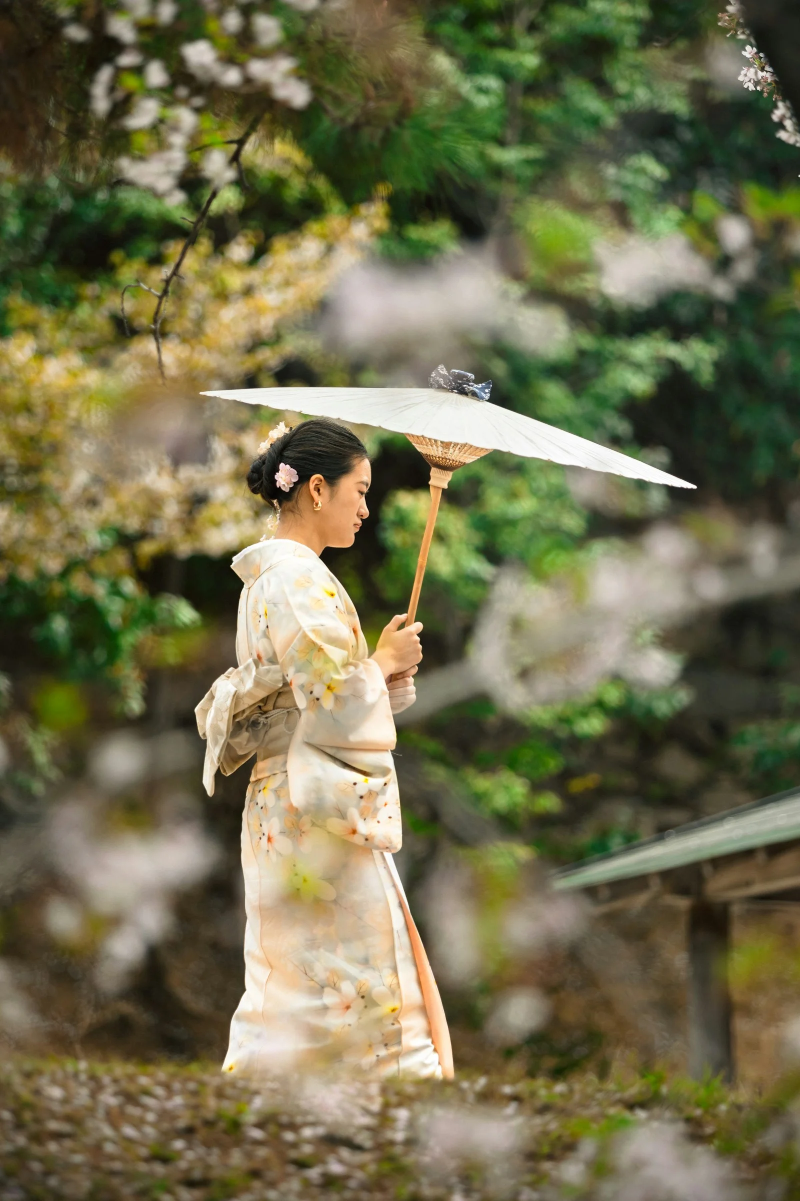 庭で傘を持つ着物姿の女性