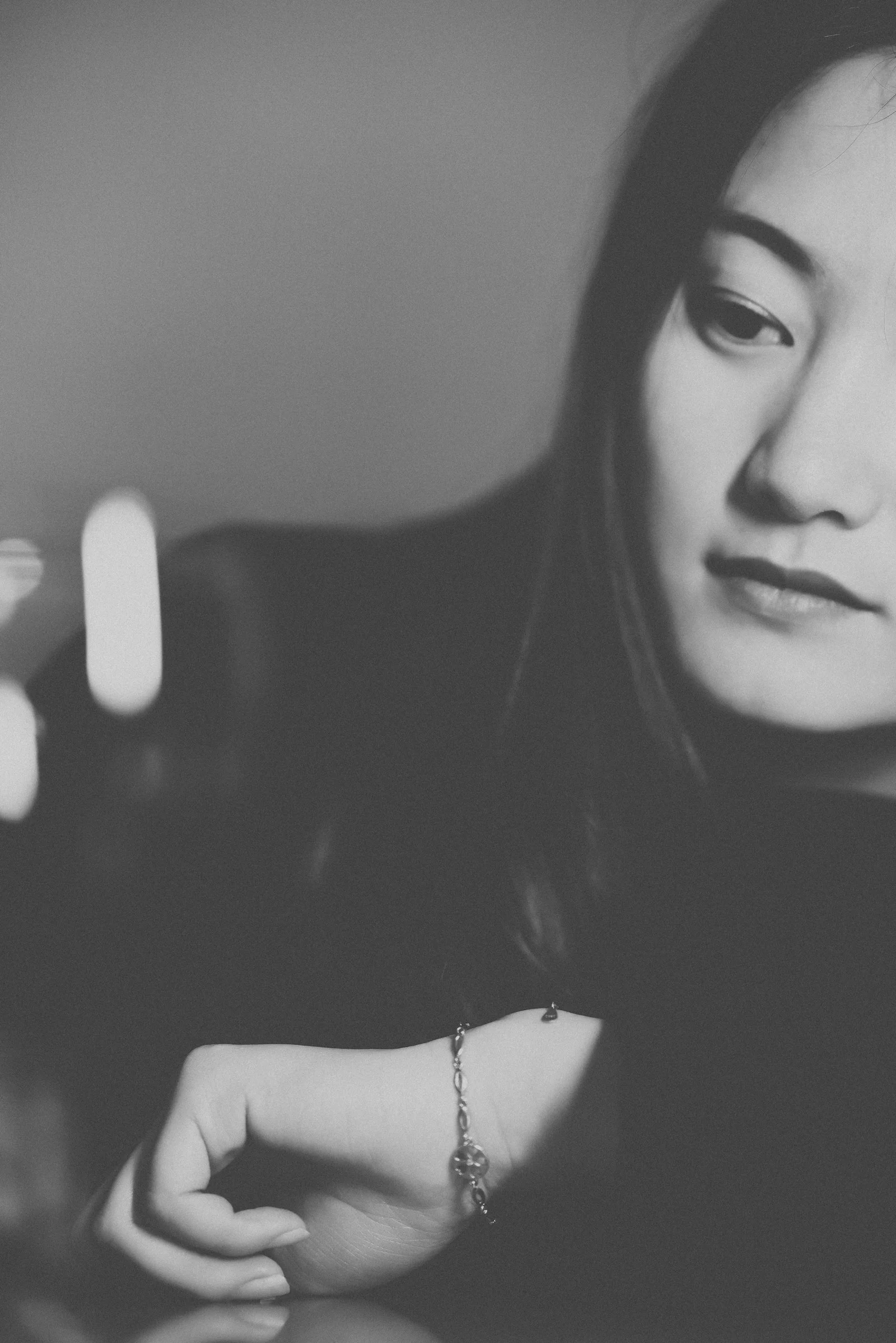 a black and white photo of a woman holding a cell phone