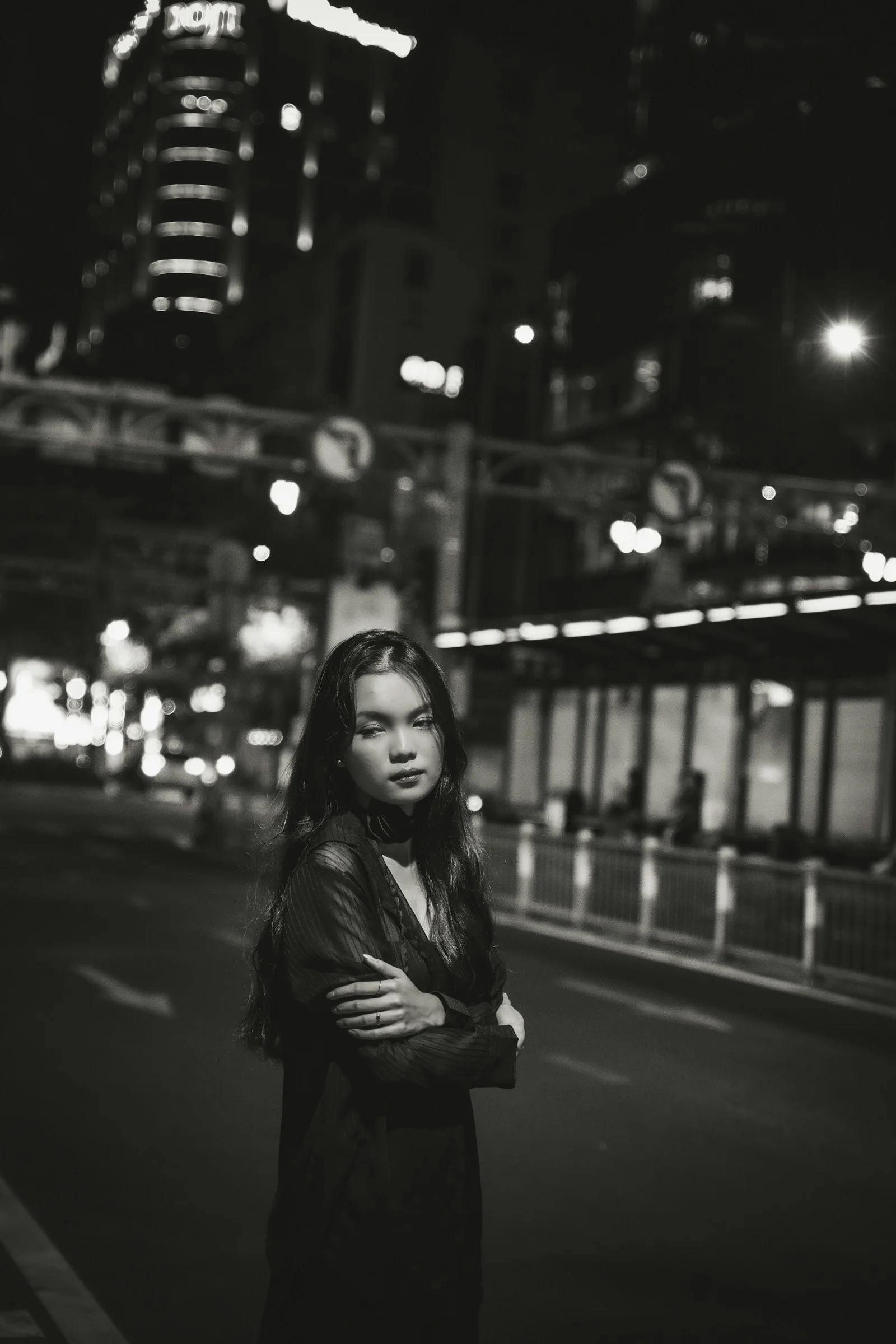 a woman standing on the side of a road at night