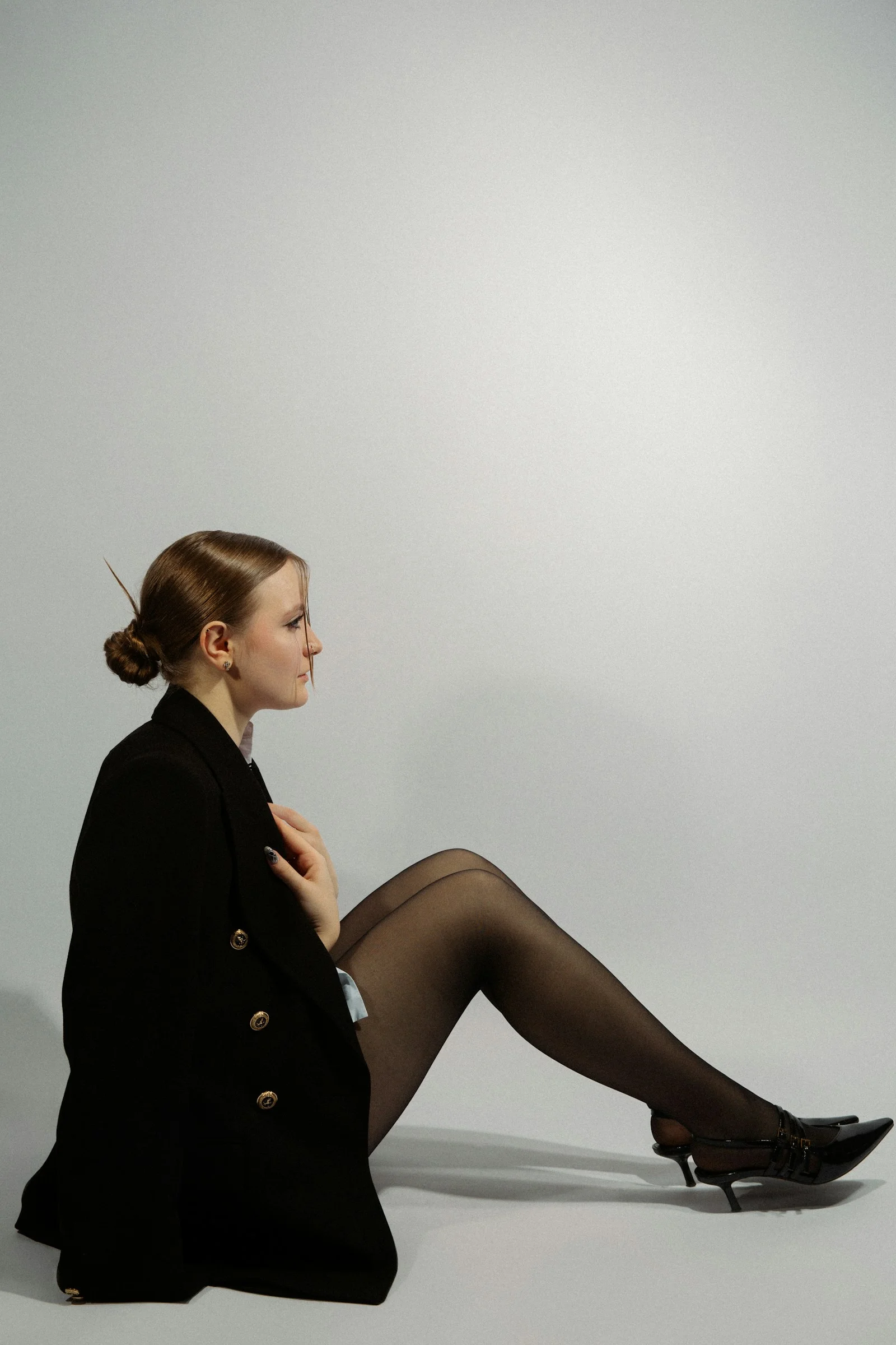 A woman poses in black attire, eyes forward