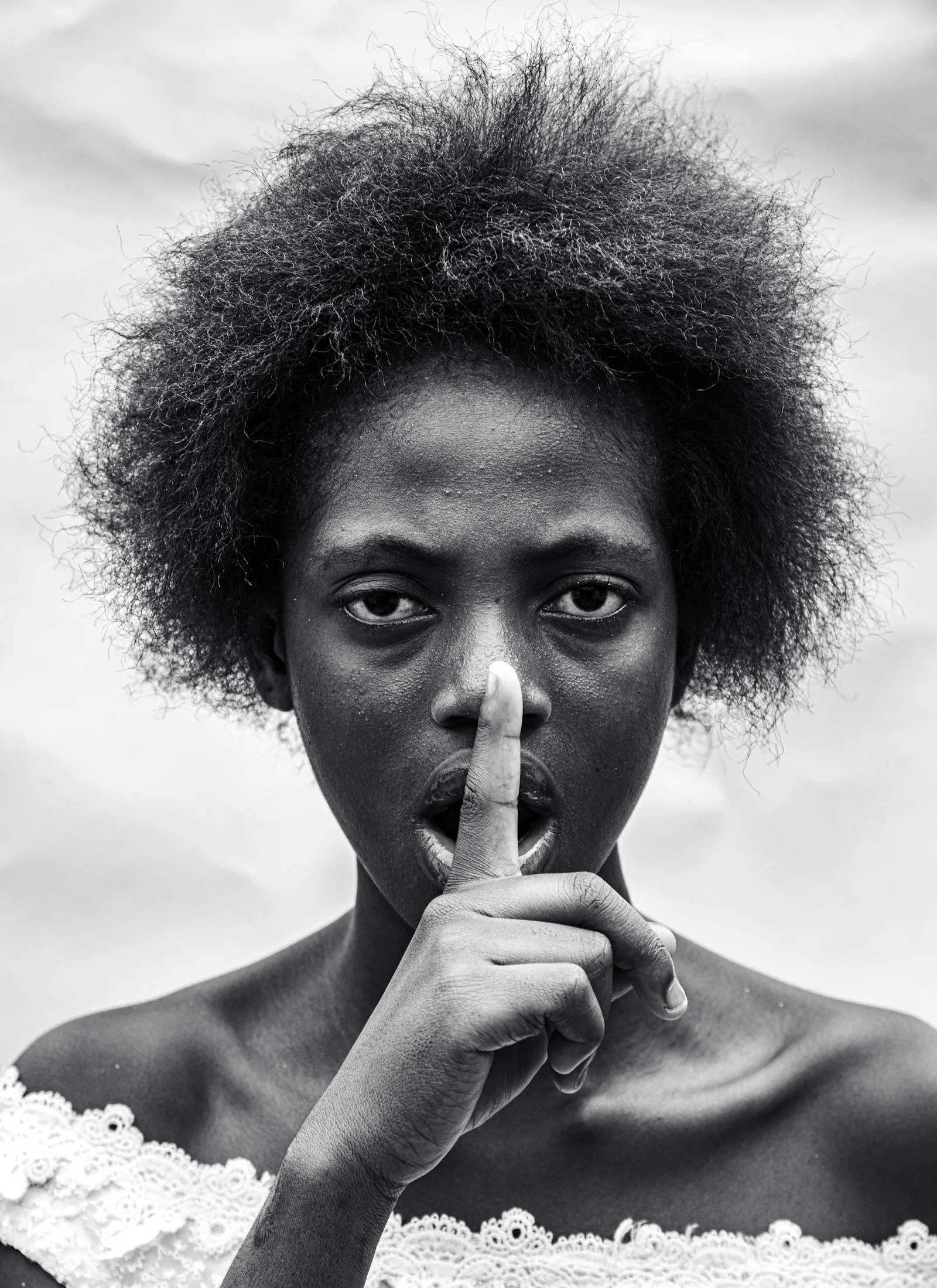 a black and white photo of a woman making a finger sign