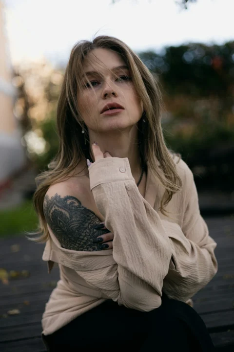 A woman with tattoos sitting on a bench
