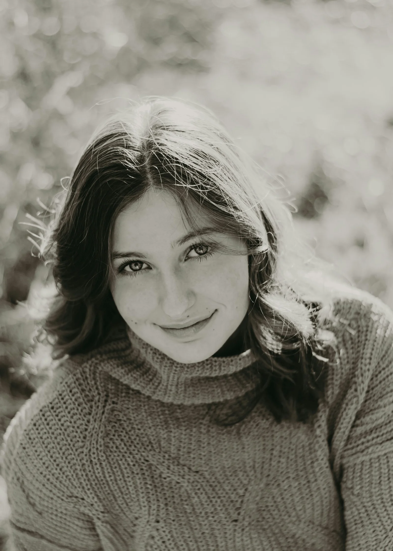 a black and white photo of a woman smiling