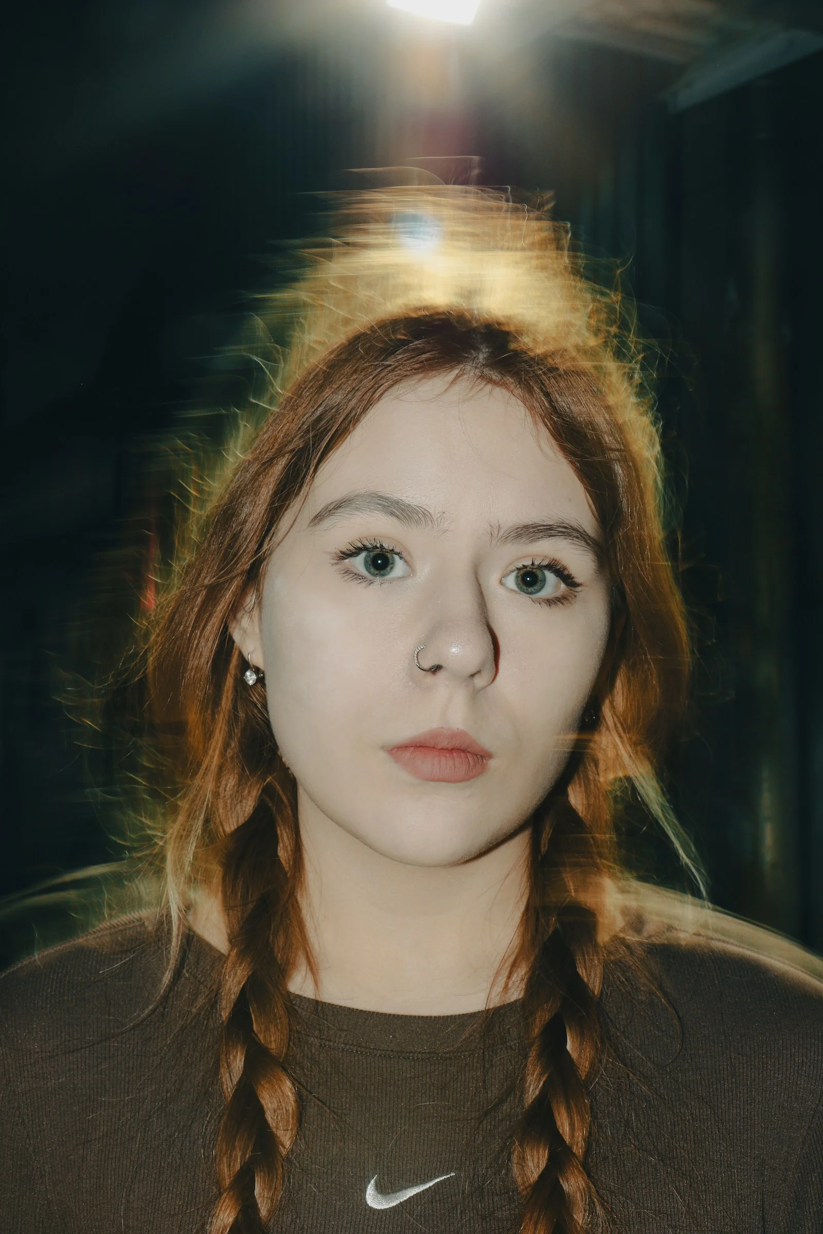 A woman with long red hair wearing a brown shirt