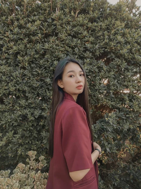 一名女人站在灌木叢前