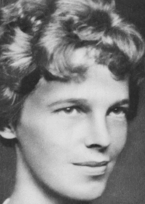 A woman with short, wavy hair in black and white