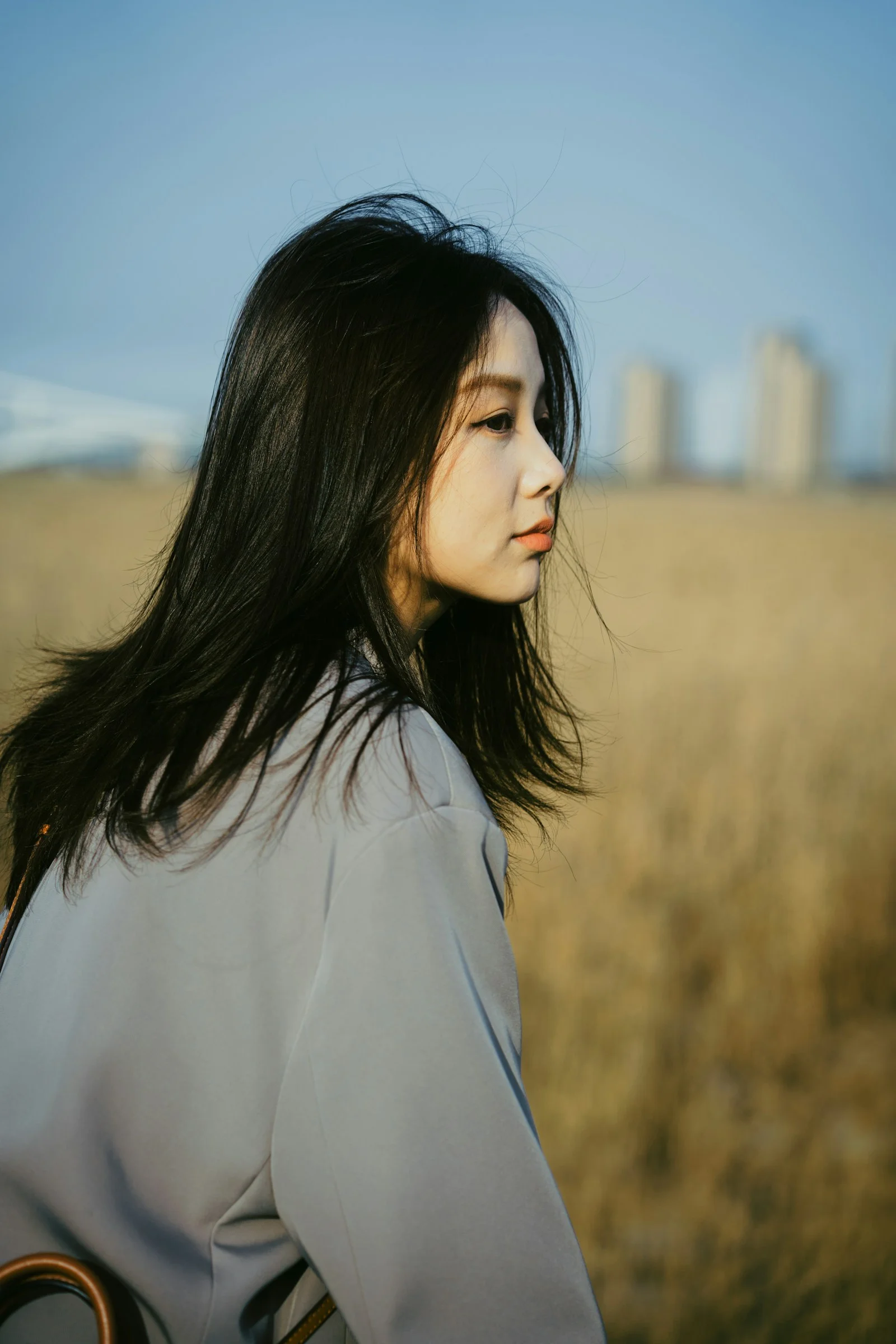留著長髮站在田野中的女子