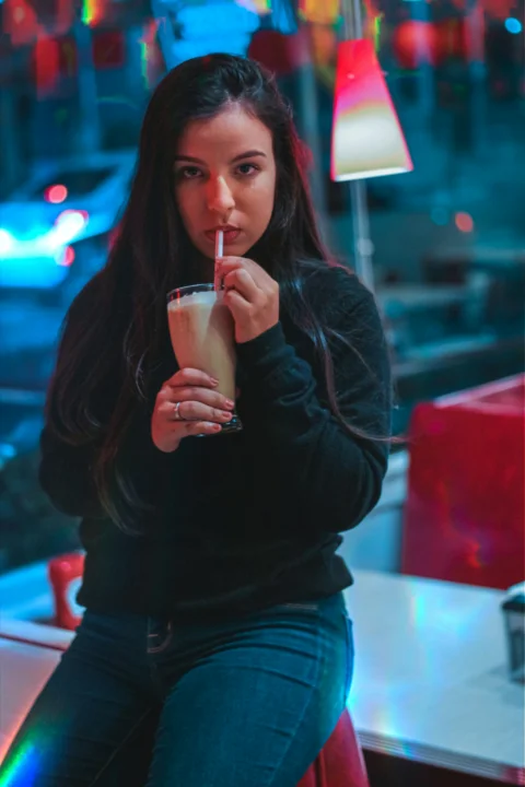 穿黑色長袖上衣的女子拿著透明水杯