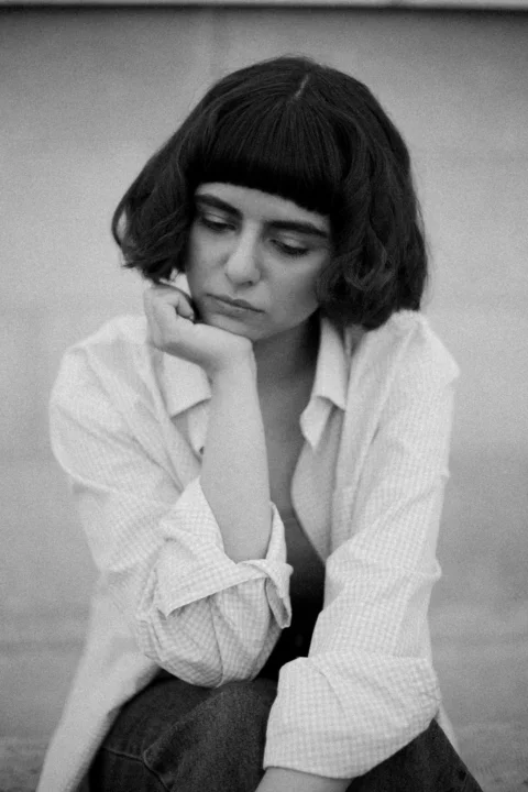 Woman with her hand on her chin, looking sad