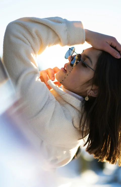 a woman in a white sweater and sunglasses