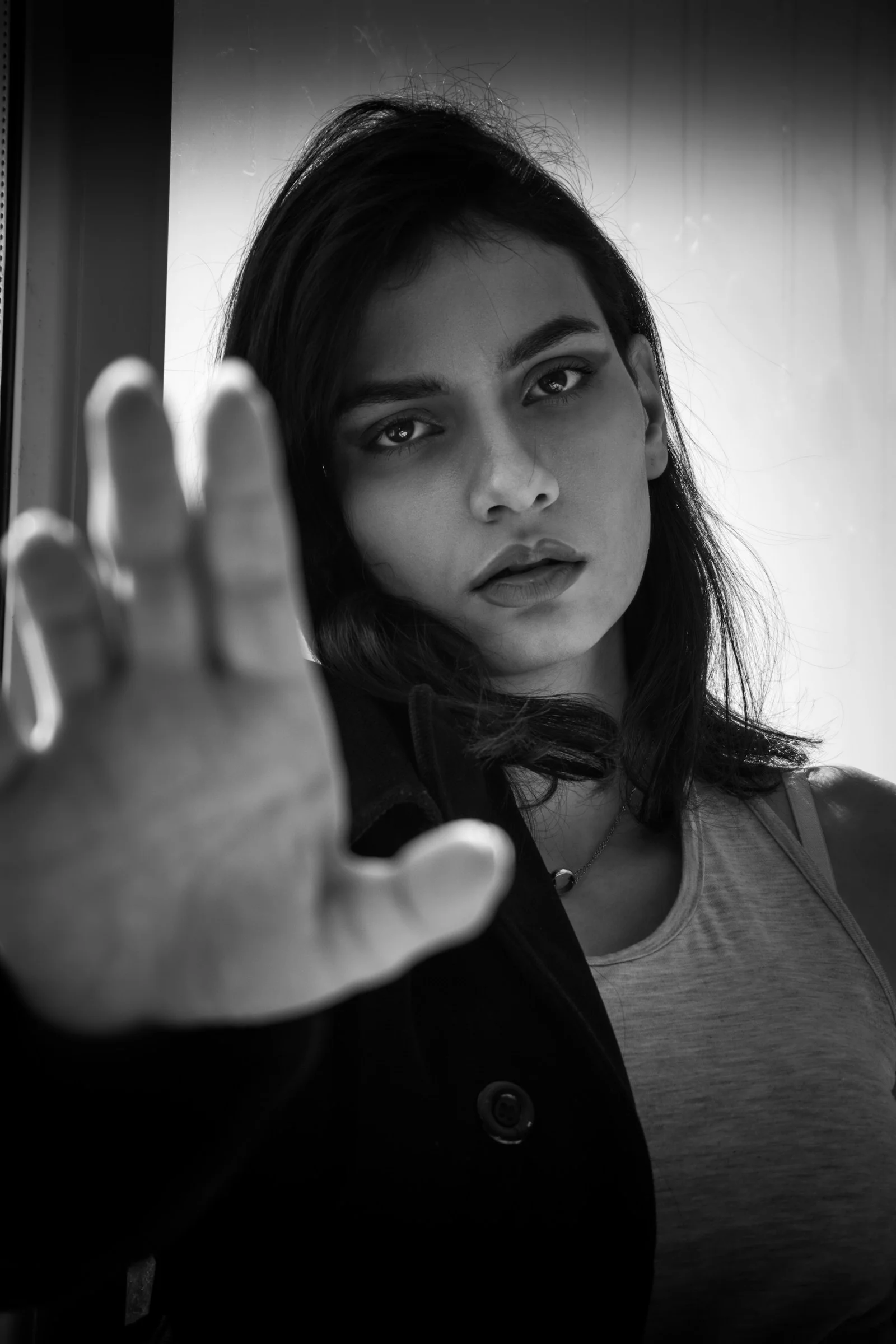 woman in black jacket holding her face