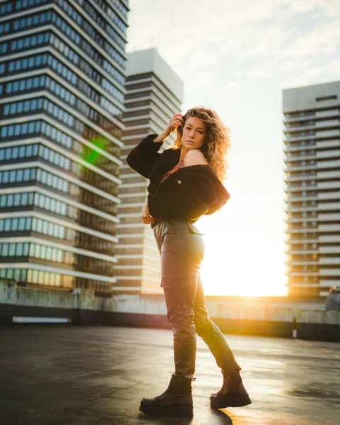 woman in black jacket and brown pants standing on road during daytime