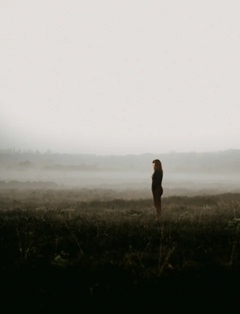 a person standing in a field with fog
