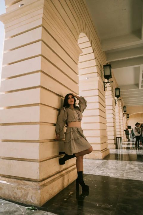 A woman poses under an archway