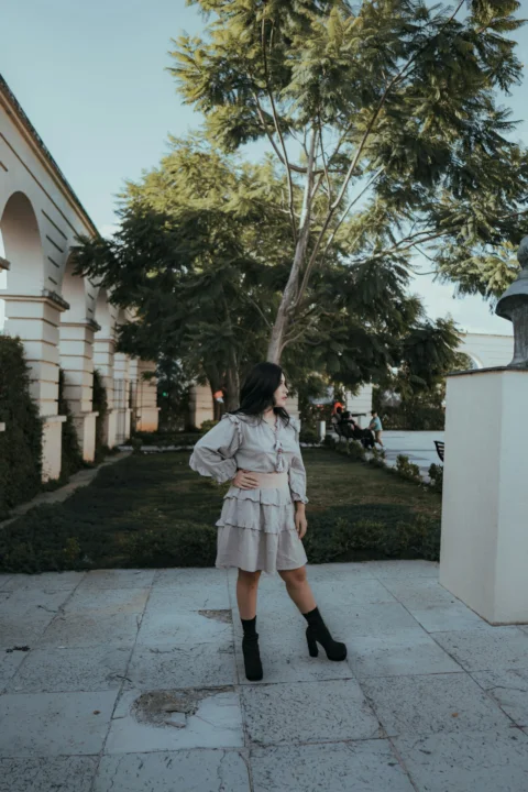 A woman poses near an old building