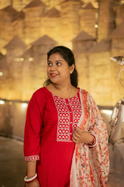 A woman in a red outfit smiles softly