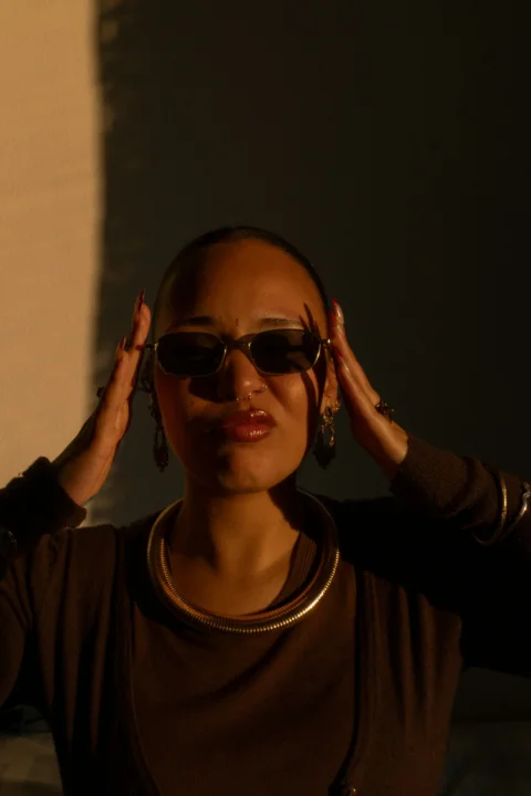 Woman wearing sunglasses and jewelry poses