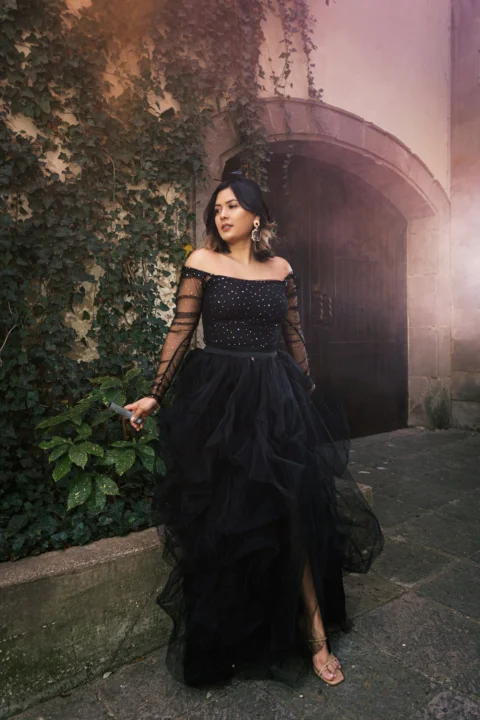 a woman in a black dress standing in front of a building