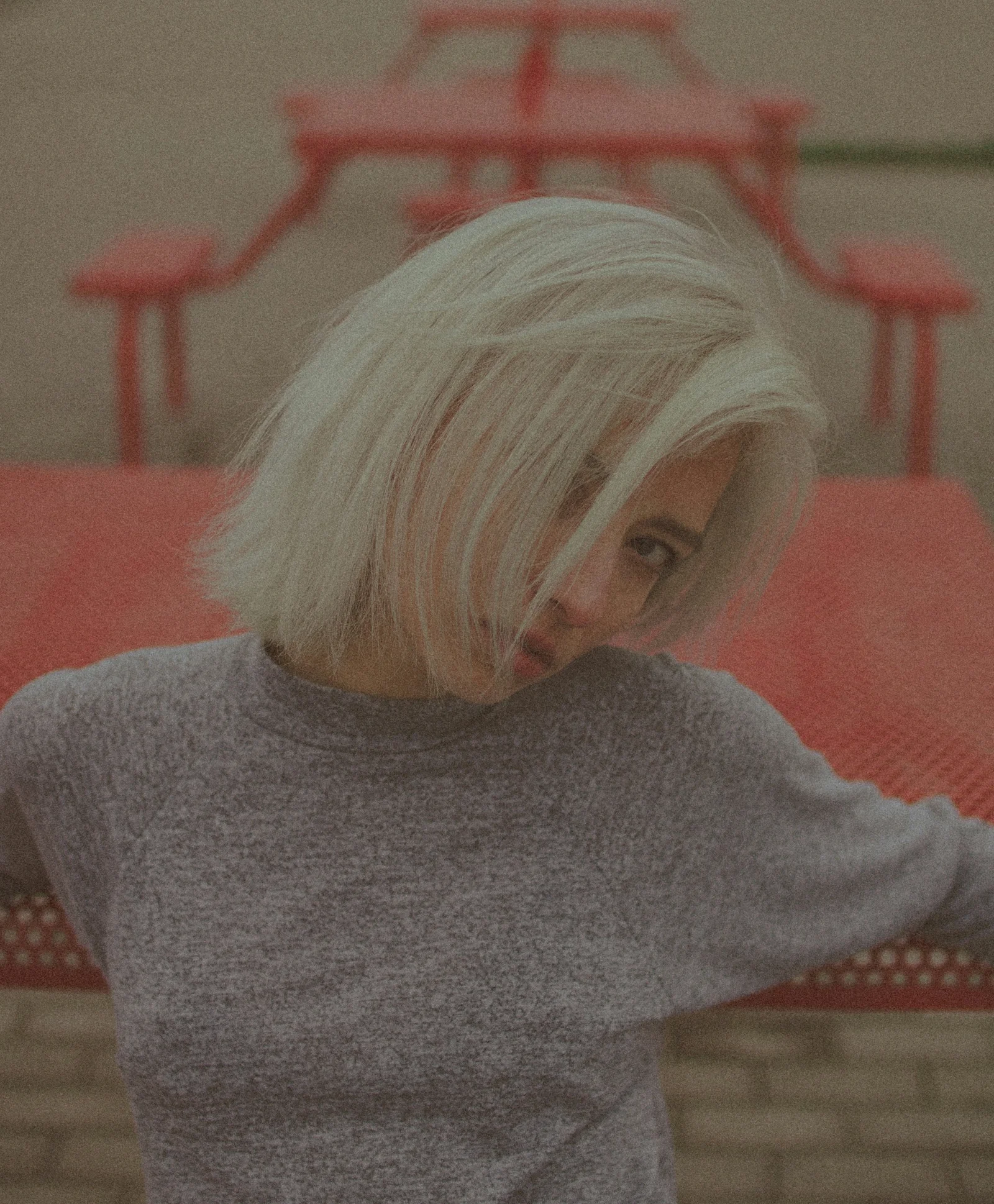 woman in gray sweater sitting on red couch