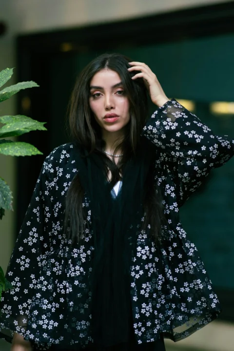 美麗的女人穿著黑色花紋夾克擺姿勢
