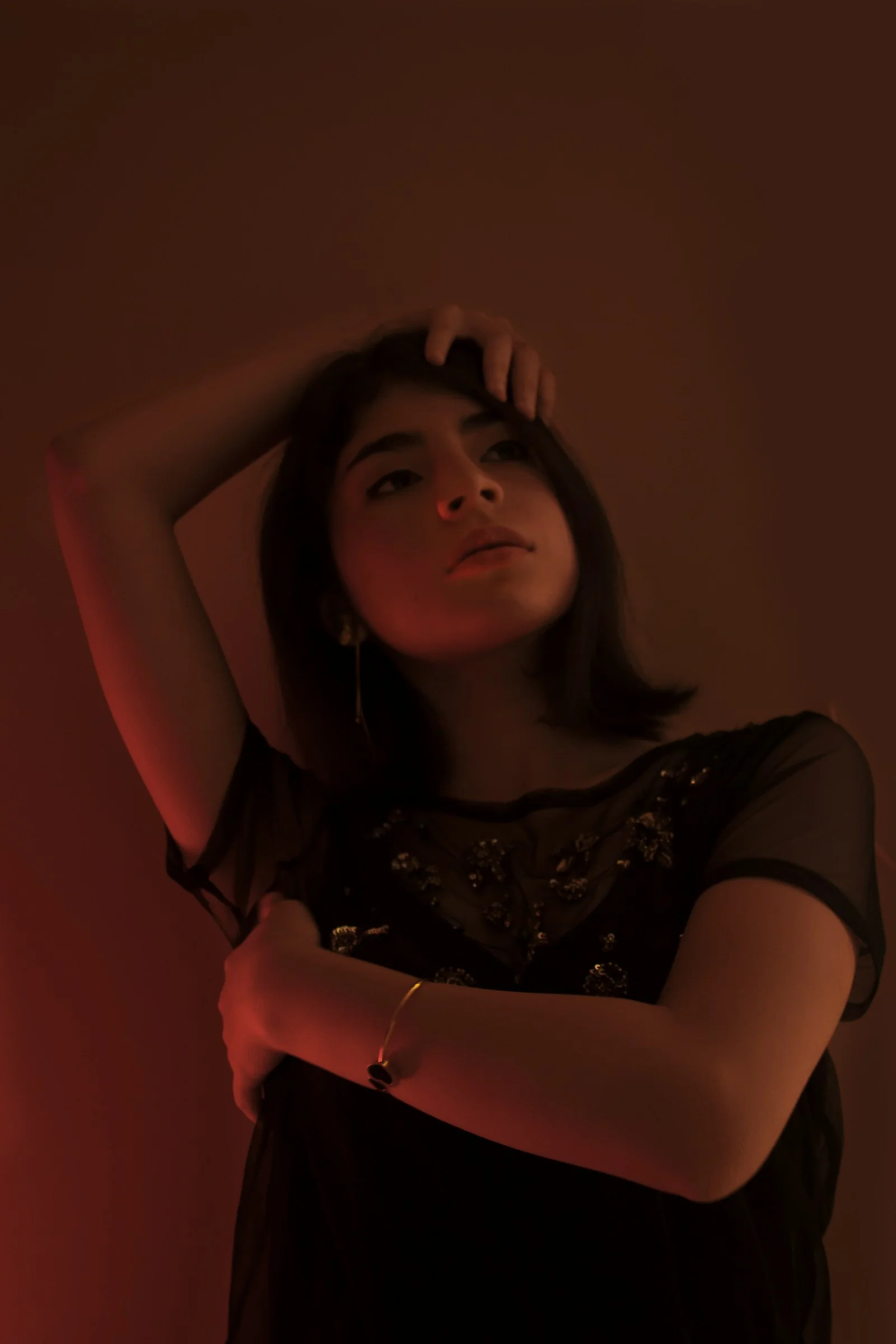 臉上映著紅光穿黑色襯衫的女子
