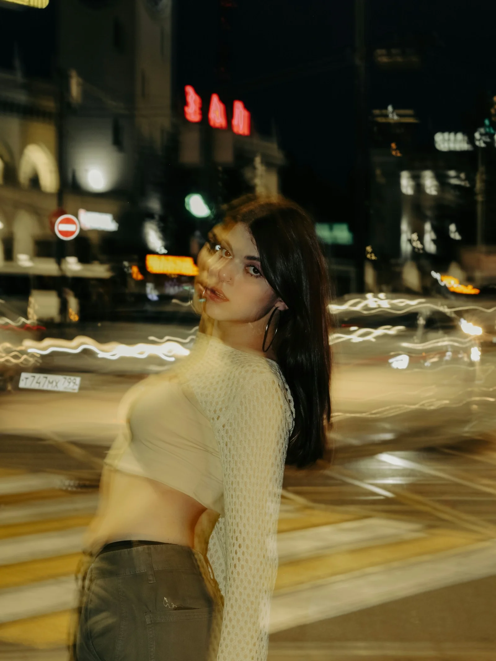 夜、通りの真ん中に立つ女性