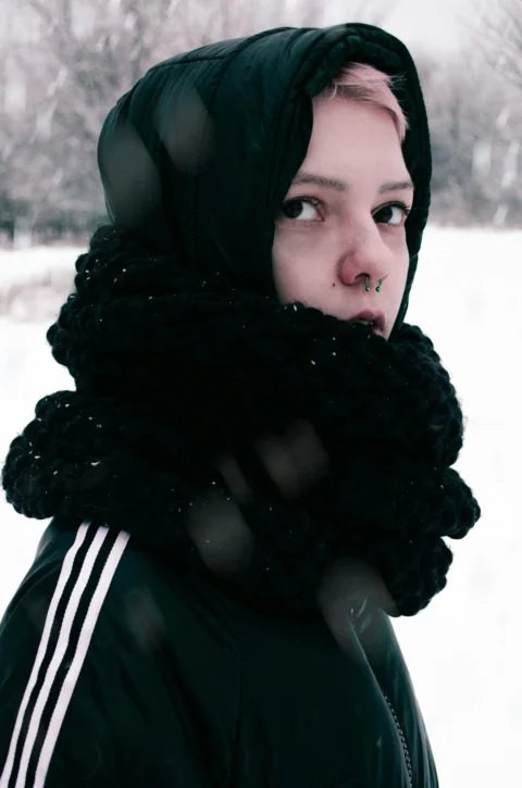 a woman wearing a black jacket and a black scarf