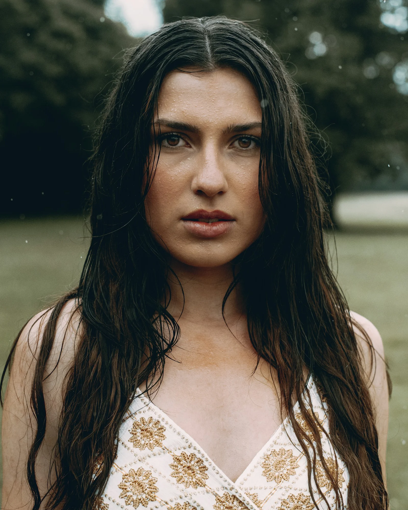 A woman with wet hair gazes intensely
