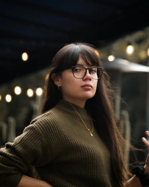 woman in black framed eyeglasses and brown sweater