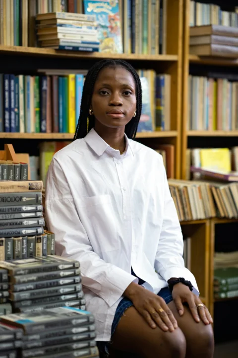 a person sitting in front of a bookshelf