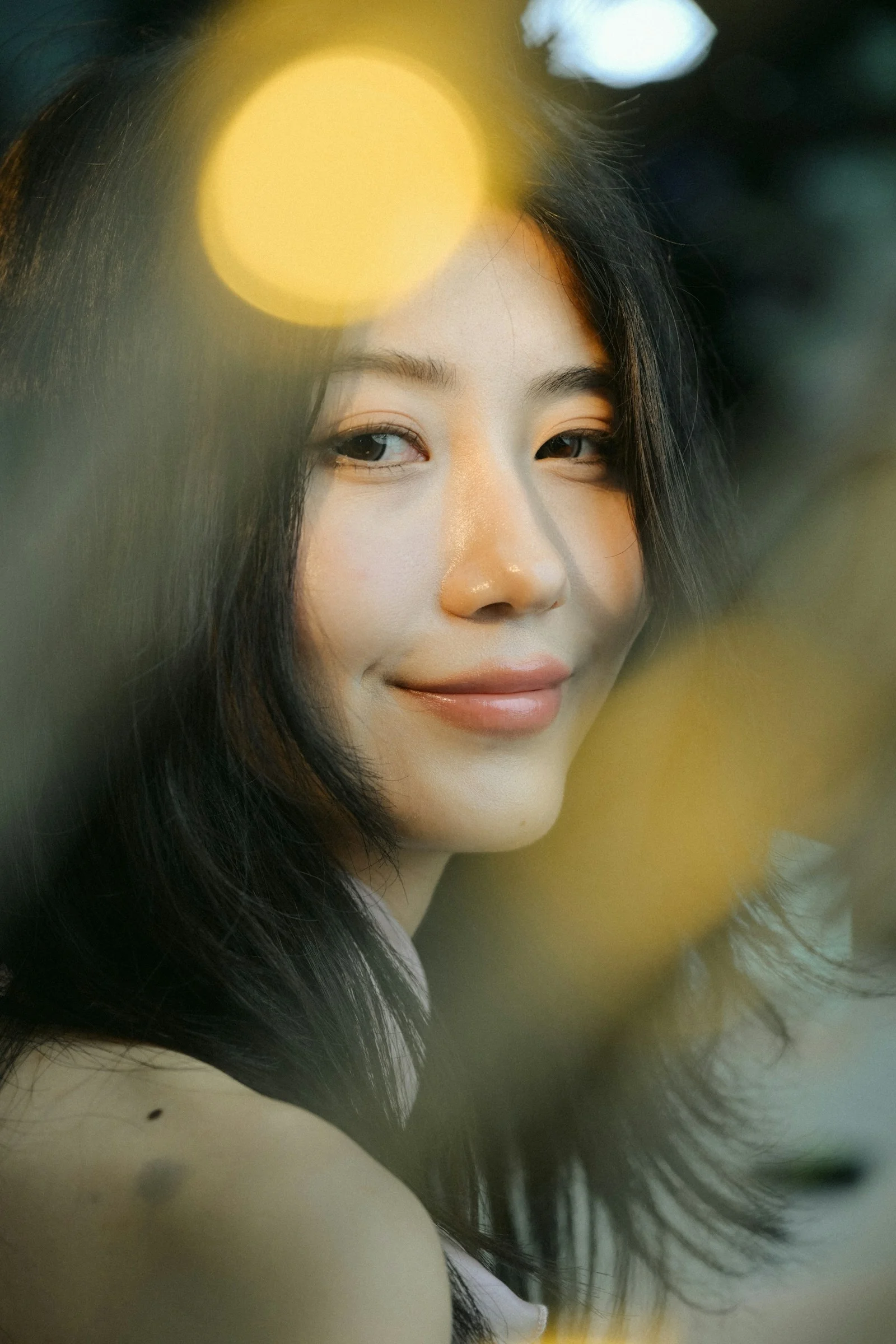 보케 불빛에 둘러싸인 긴 머리의 미소 짓는 여성