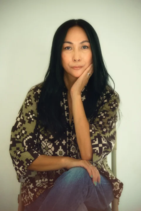 一名女子坐在椅子上，手托著下巴