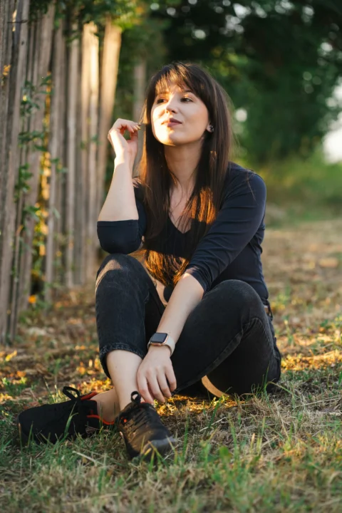 Woman sits outside, enjoying the sunlight