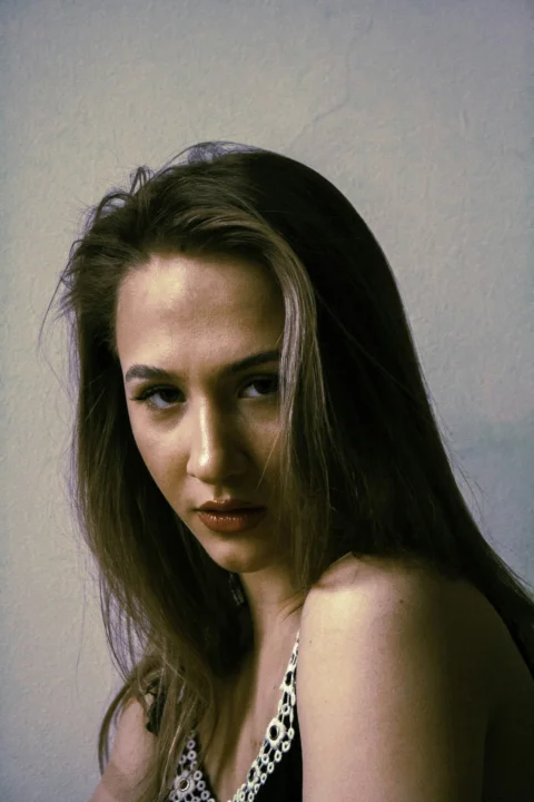 a woman with long brown hair wearing a black and white dress