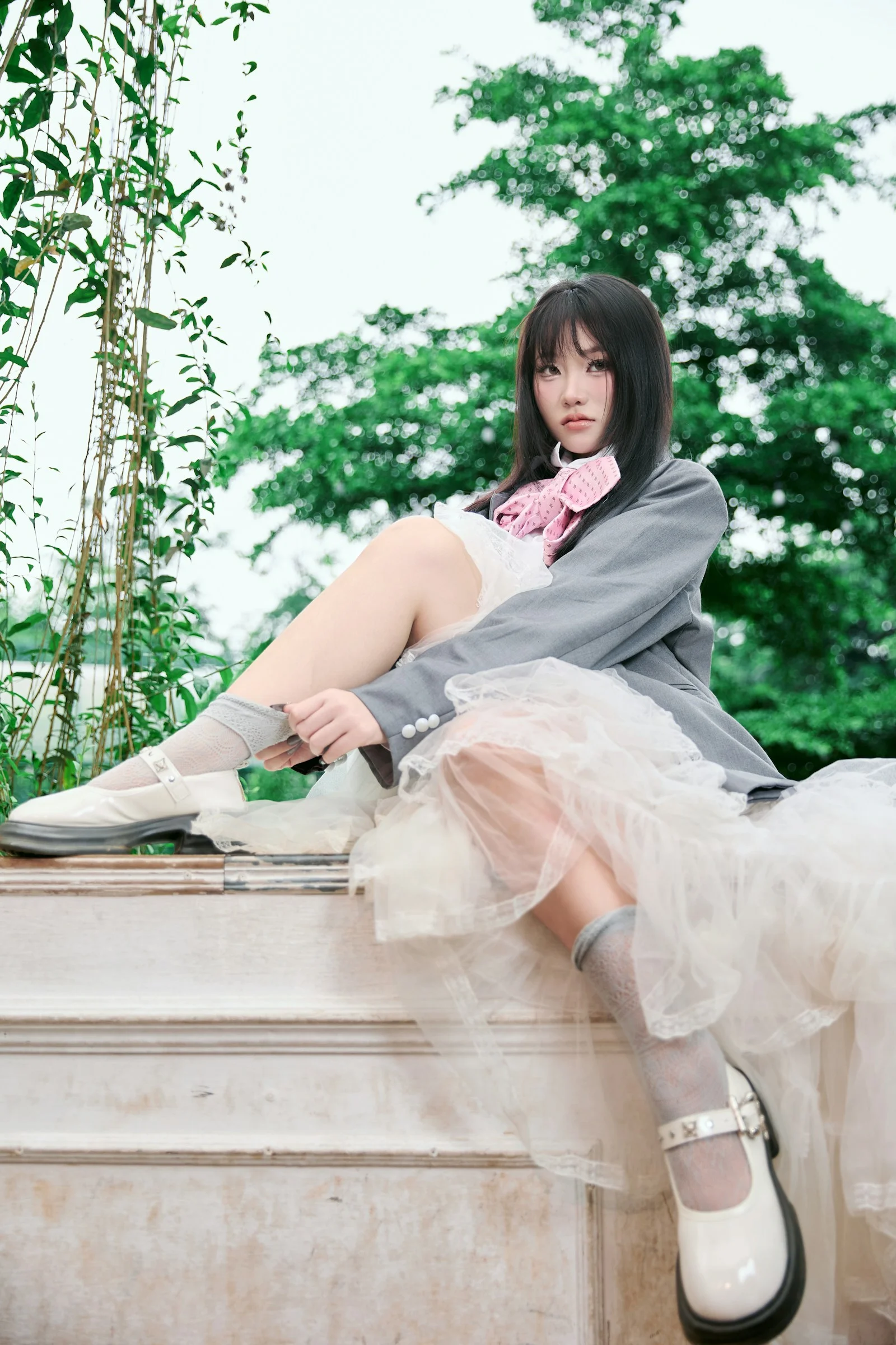 身穿灰色西装外套和白色裙子的年轻女子正在整理袜子