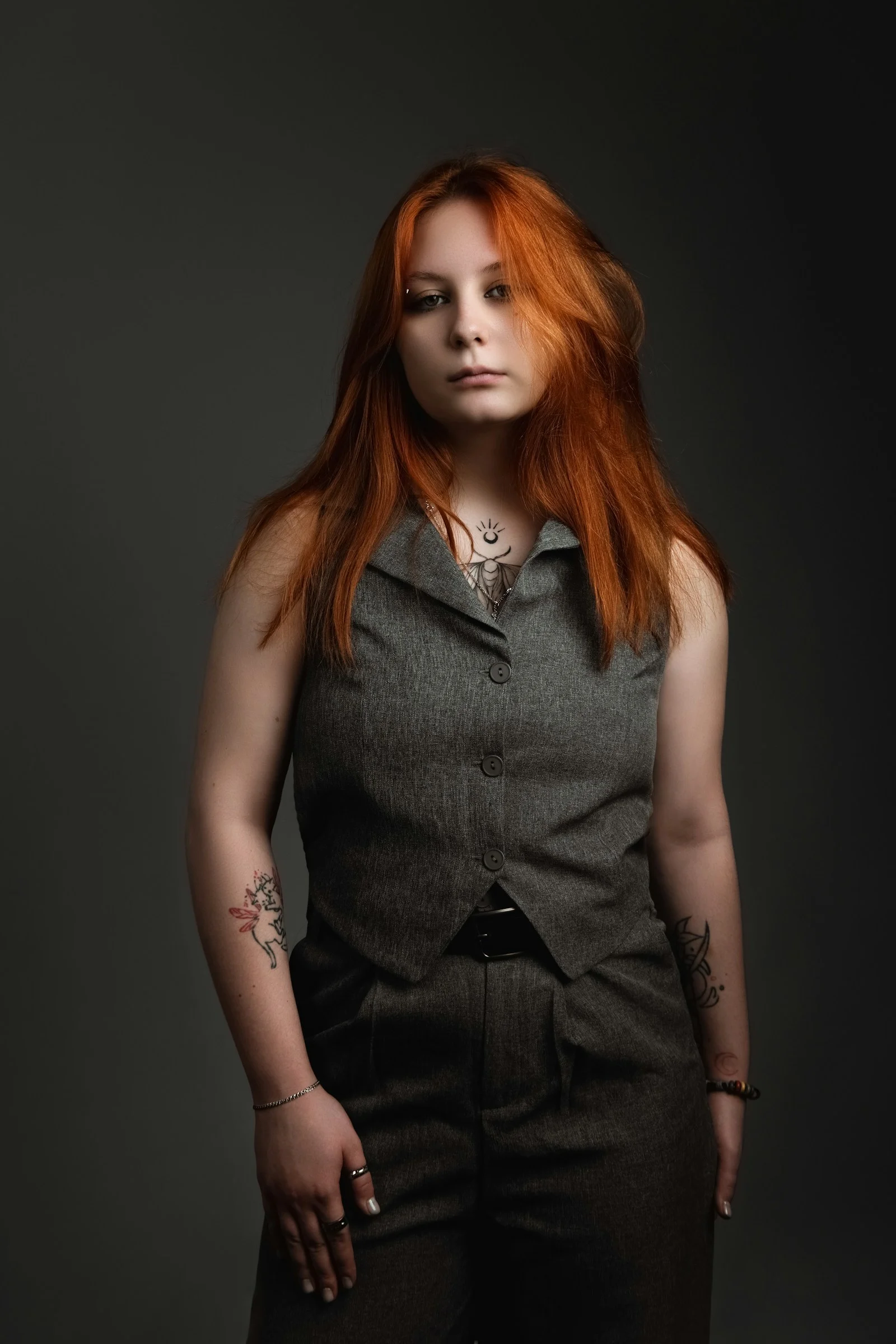 A woman with red hair standing in front of a black background