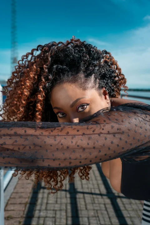 a woman with curly hair is posing for a picture
