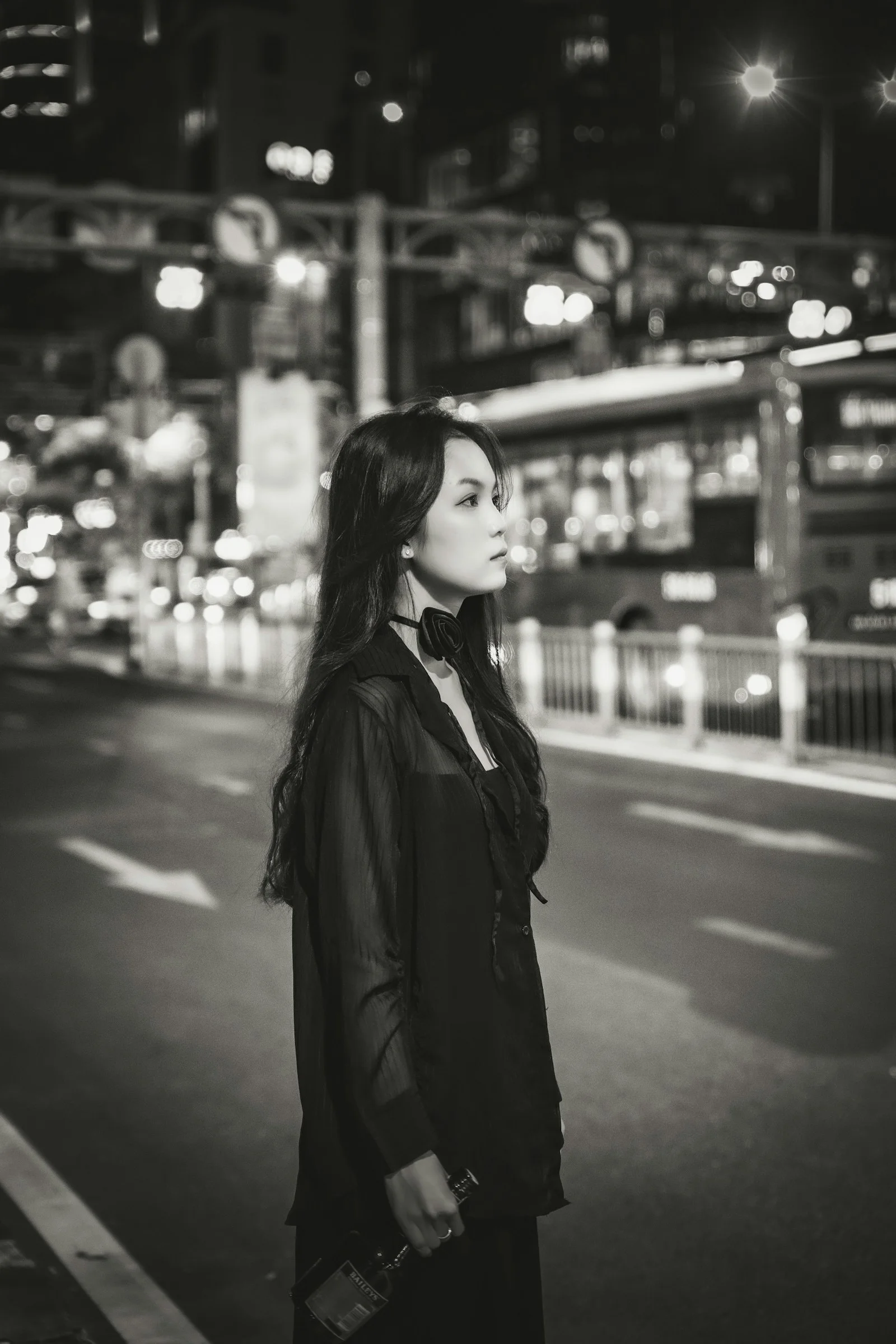 a woman standing on the side of a road at night