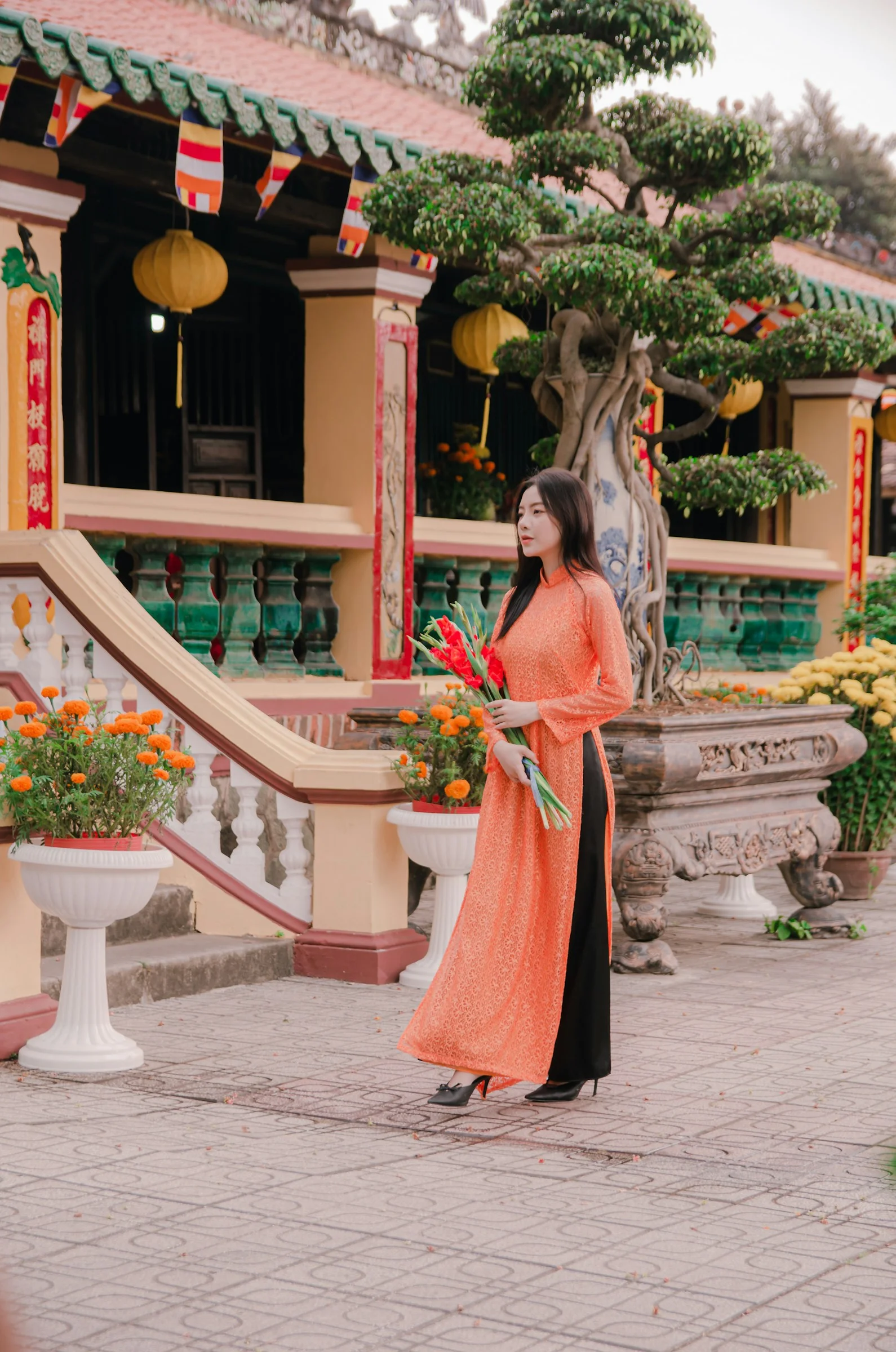 a woman in an orange and black dress standing in front of a building