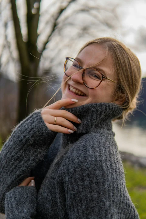 a woman wearing glasses and a gray sweater