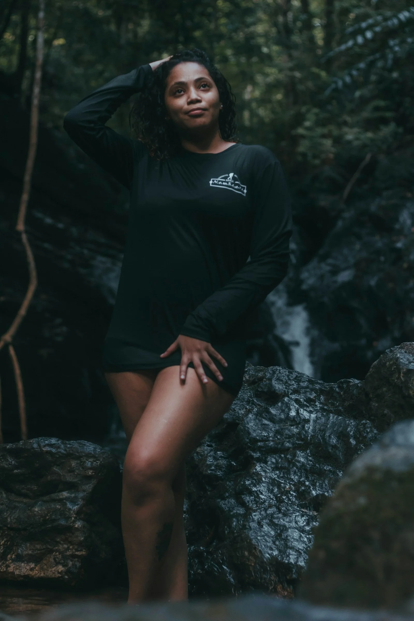 a woman standing in front of a waterfall