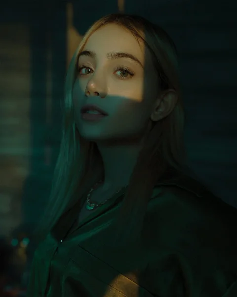 a woman with long hair standing in a dark room