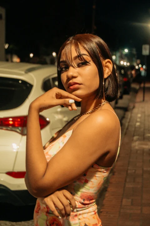 a woman standing next to a white car