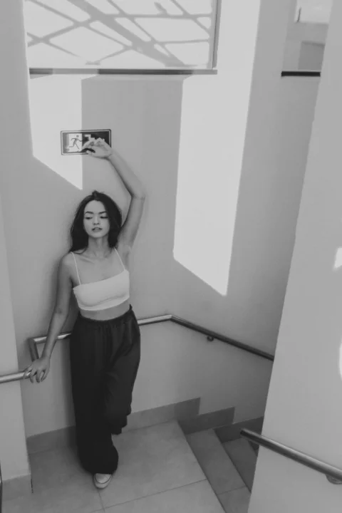 一名穿背心的女子站在樓梯間