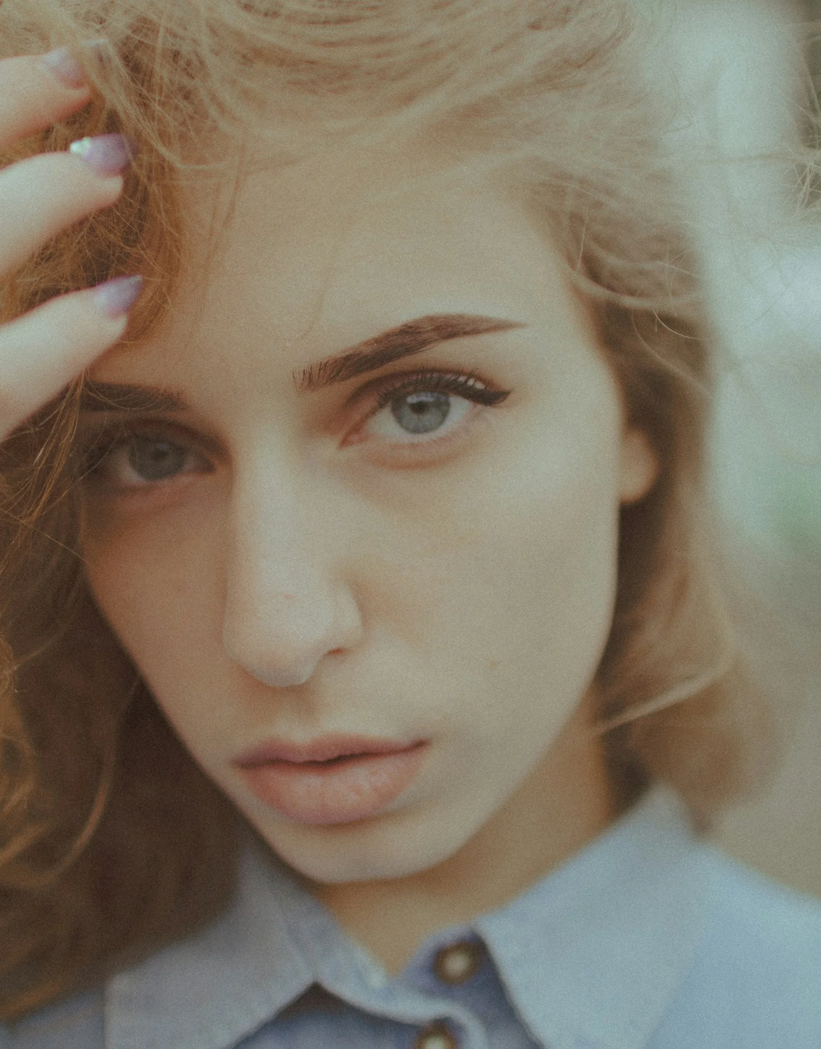 woman in white shirt holding her hair