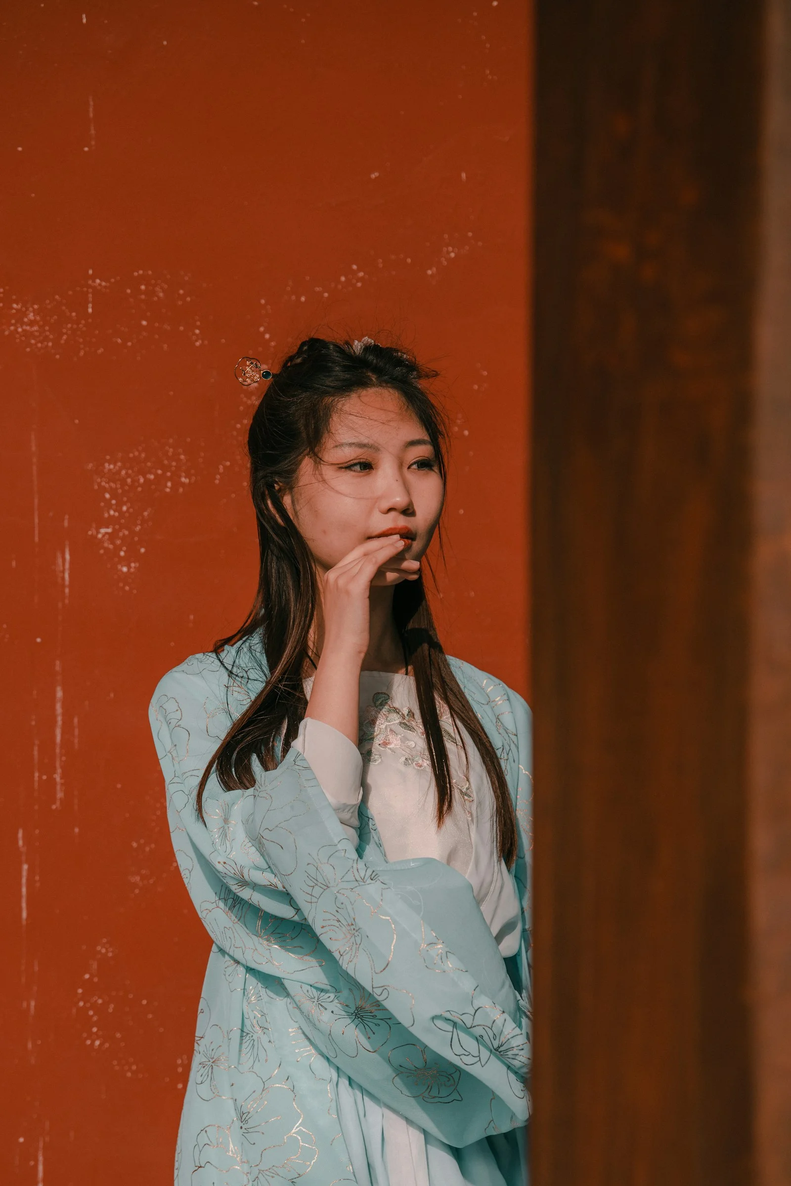 一位站在红墙前的女士