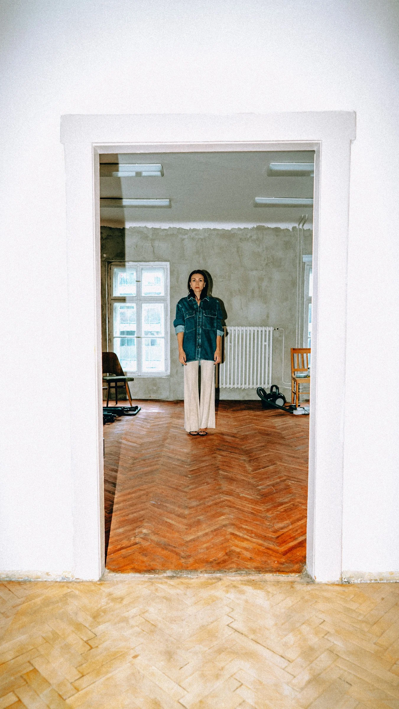 A person standing in a room with a hard wood floor