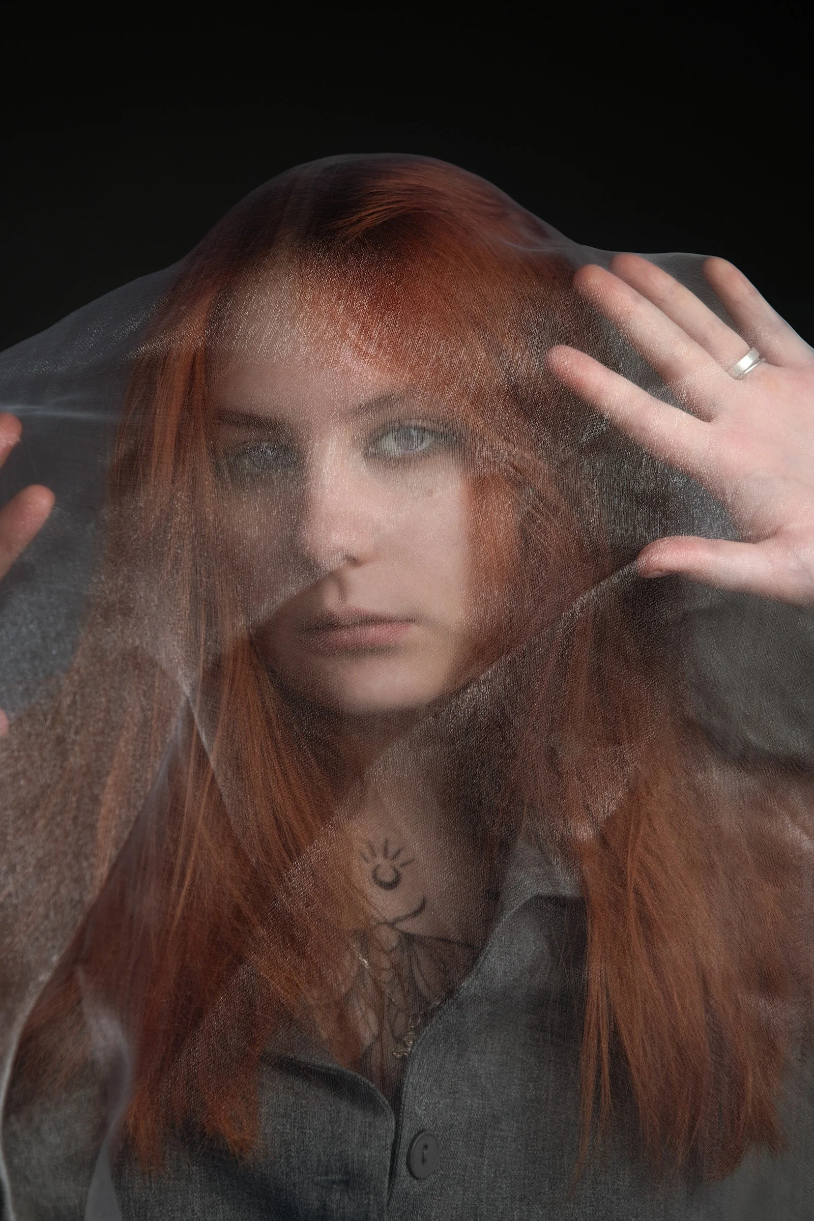 A woman with red hair is covering her face