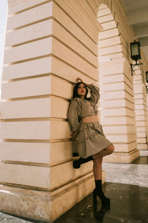 Woman poses gracefully under an architectural archway
